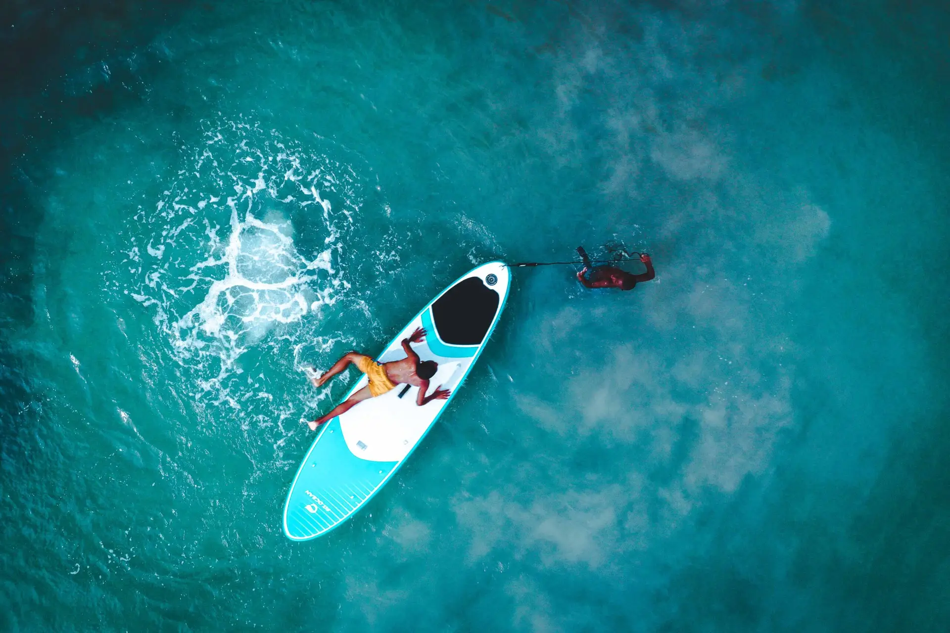 Niños juegan con tabla de surf en el mar de la Ilsa de Providencia
